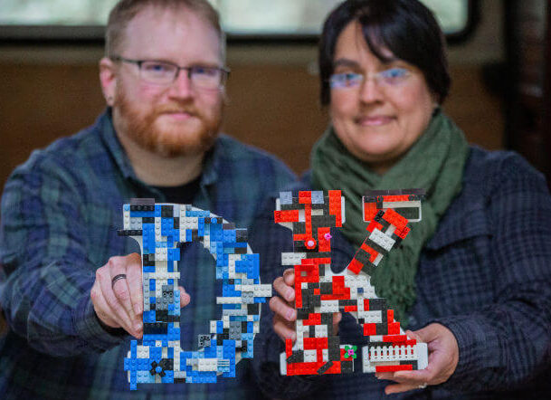 David and Kate, owners of This Brick Life, holding their initials made out of Lego